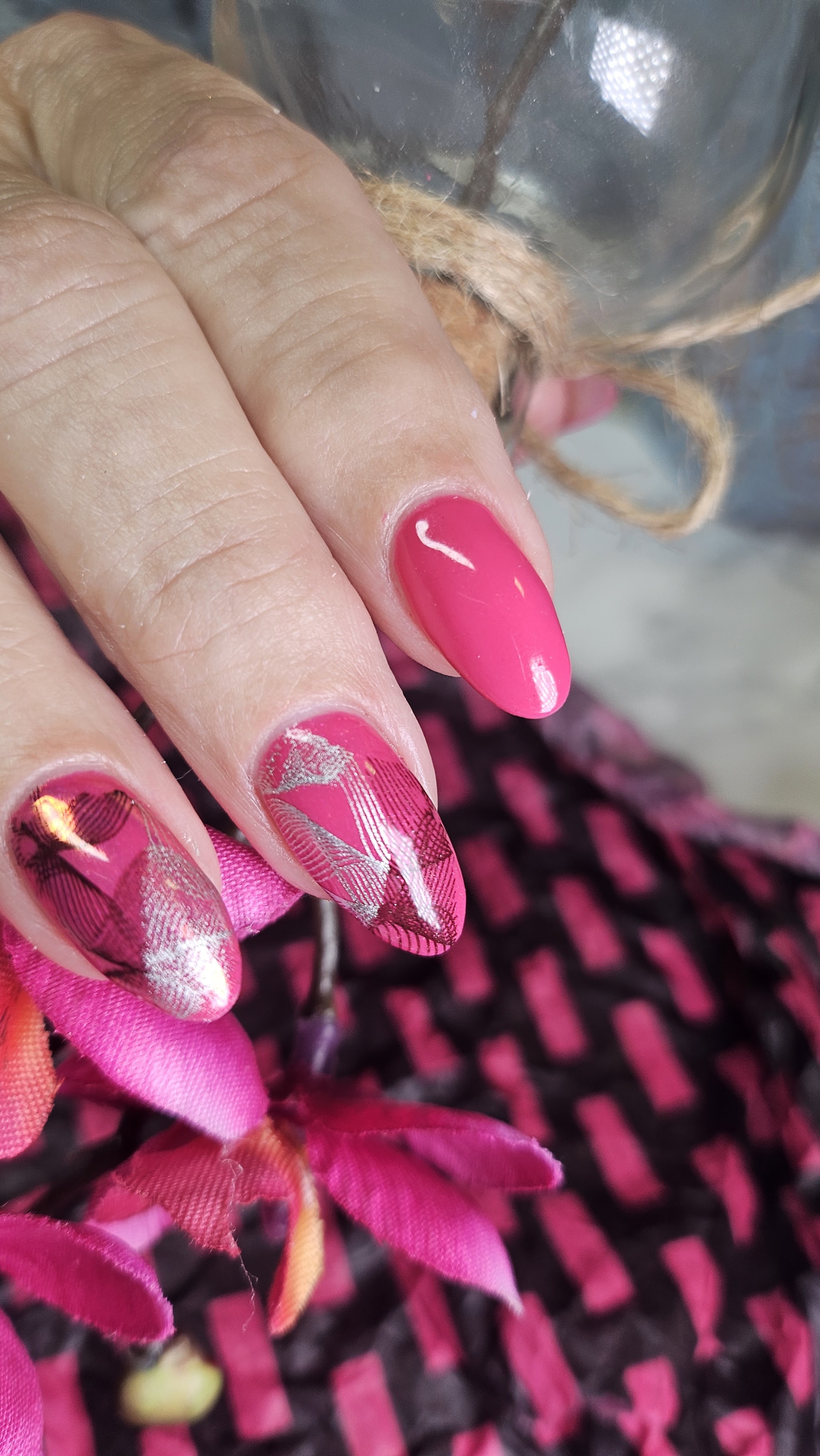 Felroze amandelnagels, twee nagels met folie en blaadjes